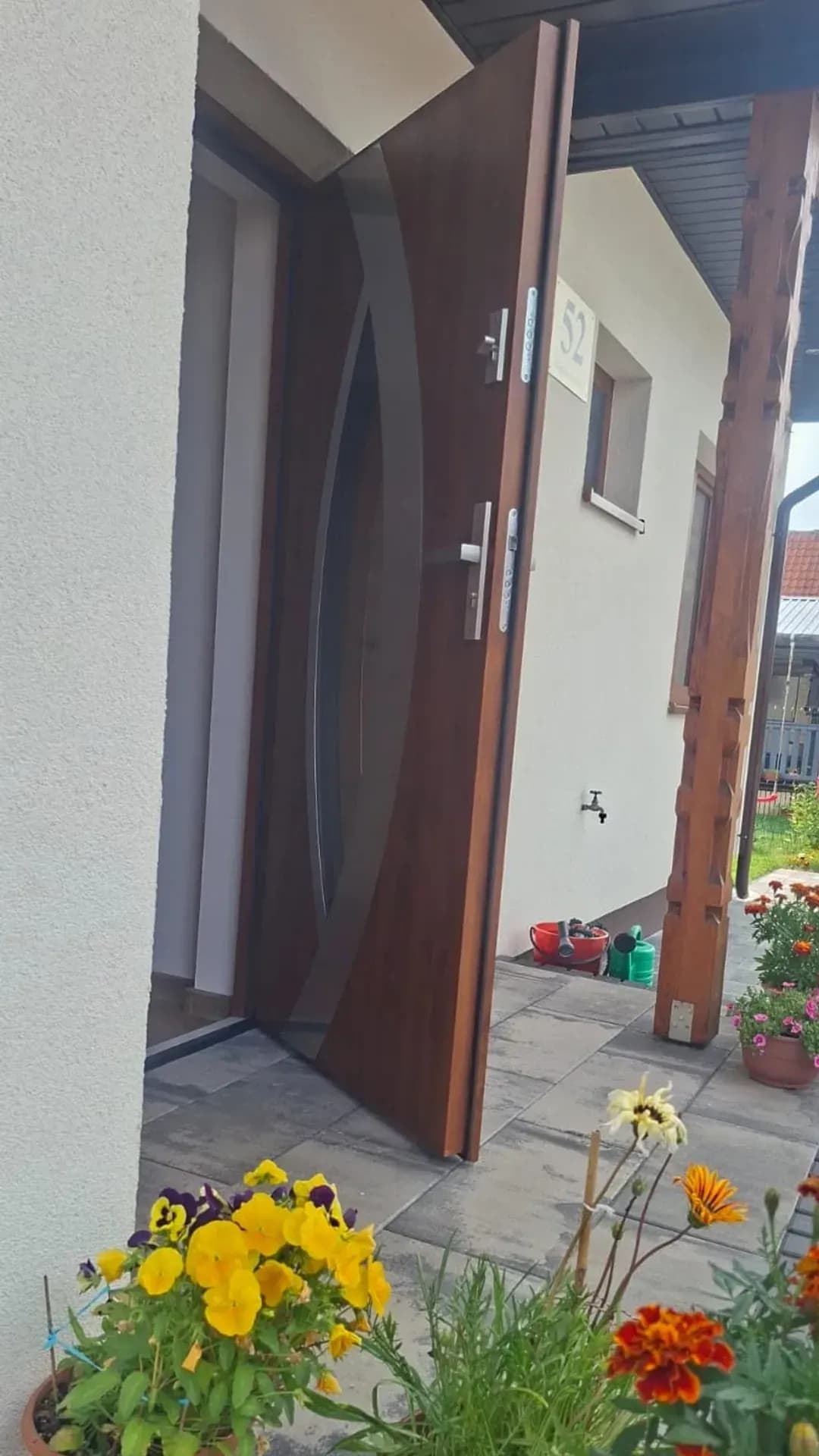 Otwarte drzwi wejściowe z owalnym przeszkleniem, widok od podjazdu — realizacja MP Studio, Pisz i okolice